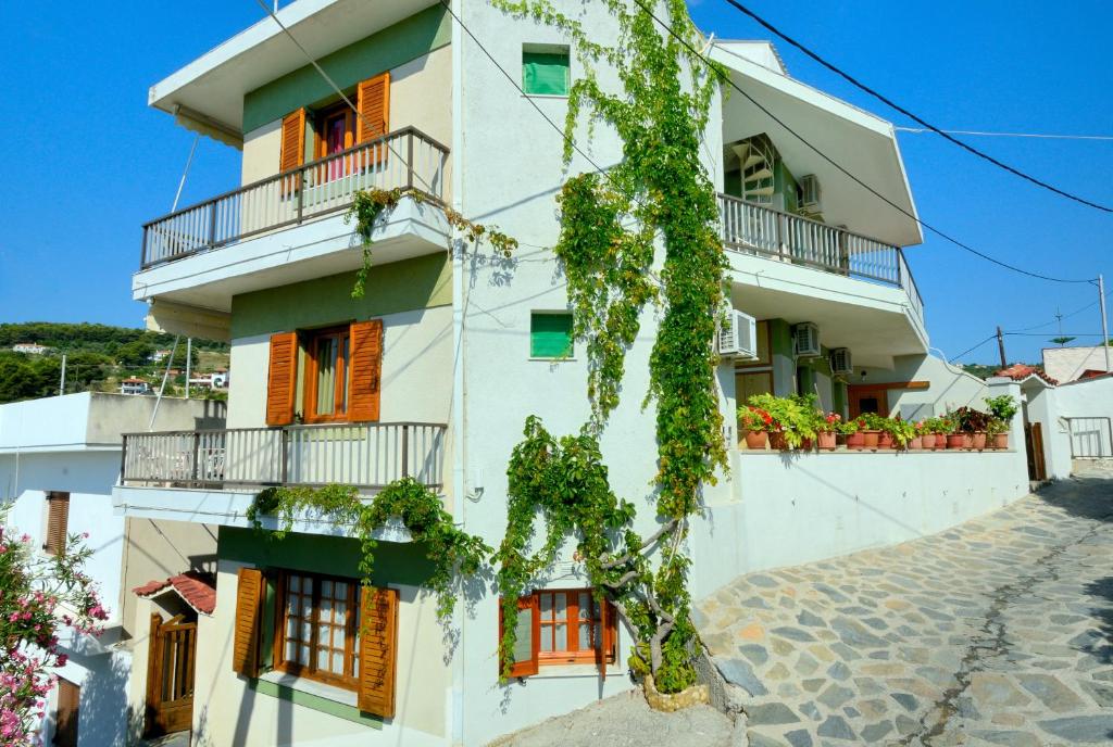 a white building with orange doors and ivy at Anais Studios in Patitiri