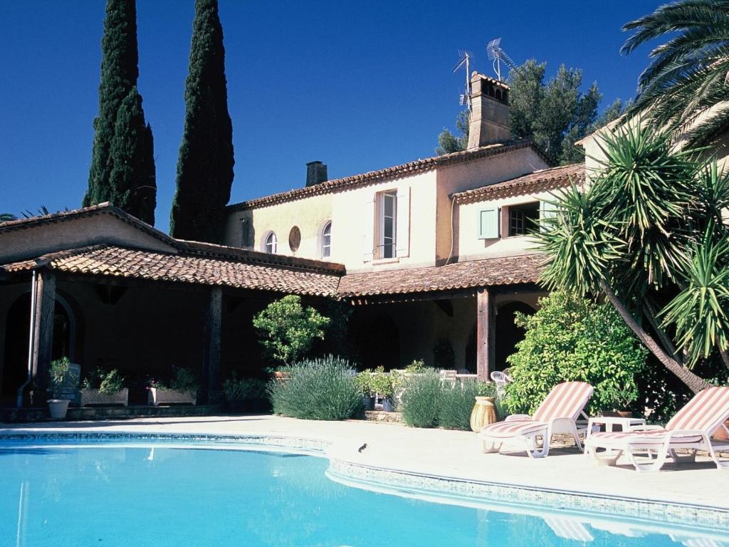 une villa avec une piscine en face d'une maison dans l'établissement Chateau Maravenne, à La Londe-les-Maures