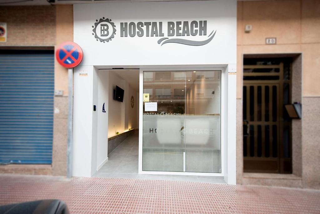 eine Haustür eines Krankenhausstrandes mit einem Schild darauf in der Unterkunft Hostal Beach in Santa Pola
