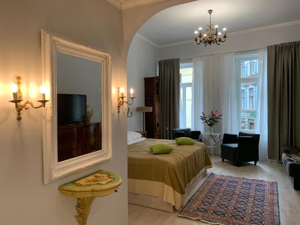 a bedroom with a bed and a mirror and a living room at NB Apartments Riga Old Town in Rīga