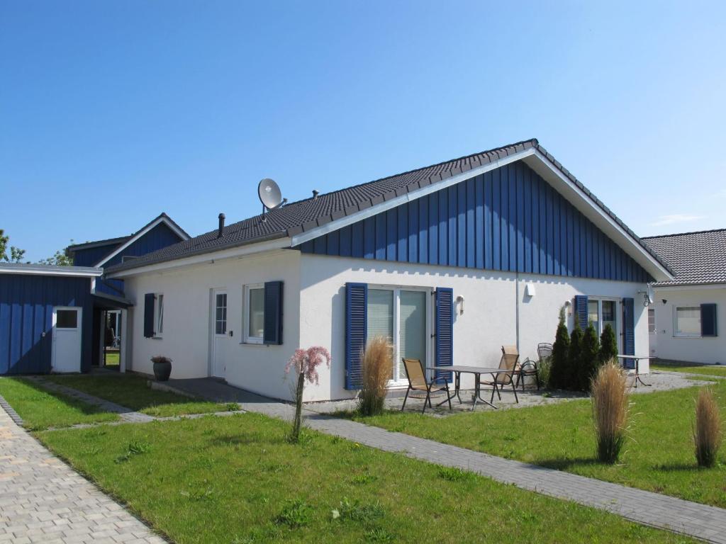 a white house with a blue roof at Holiday Home Heide by Interhome in Altefähr