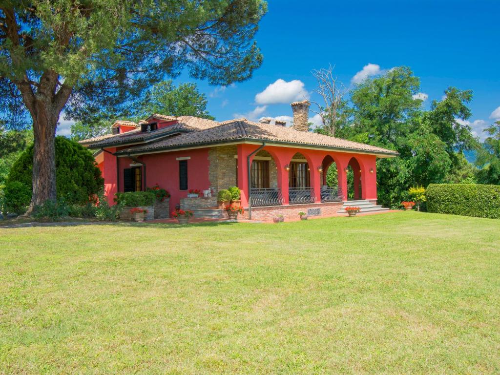 a red house with a large lawn in front of it at Villa Villa Taioli by Interhome in Montecarlo