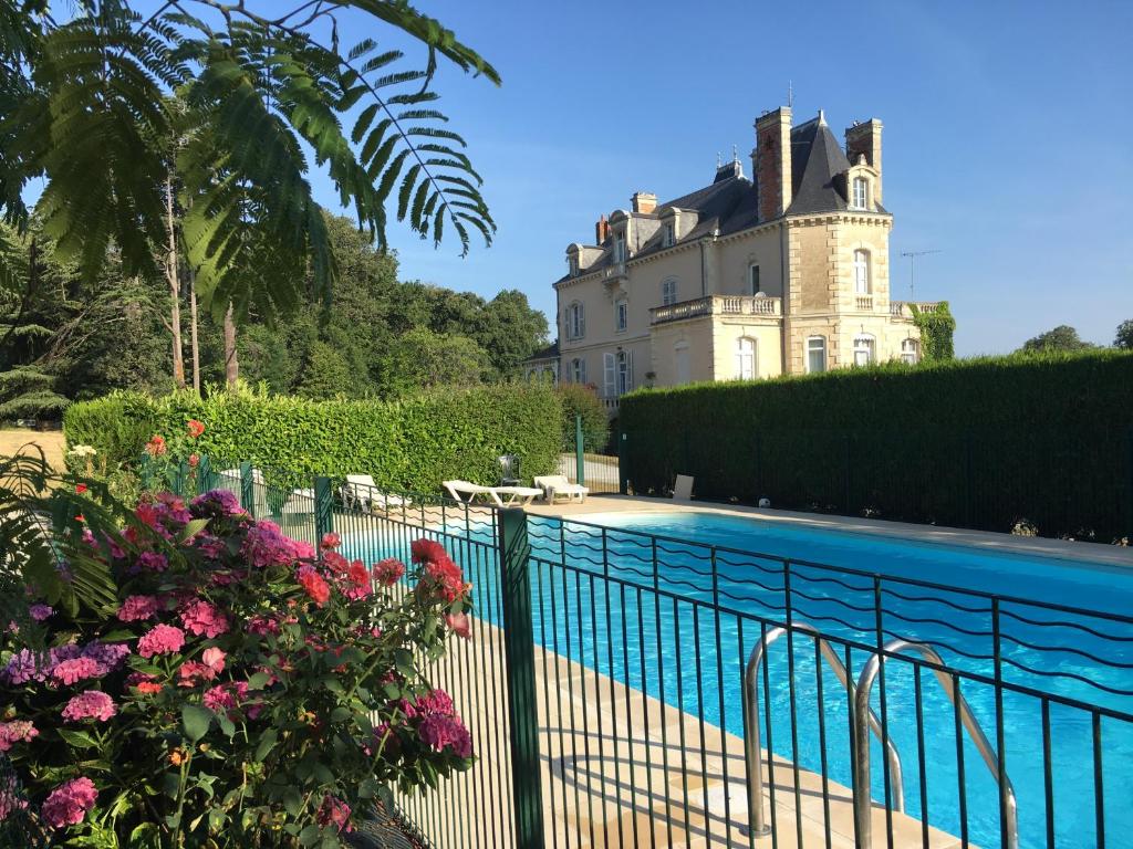 una casa con piscina frente a un edificio en Loire Valley Cottages, en Jarzé