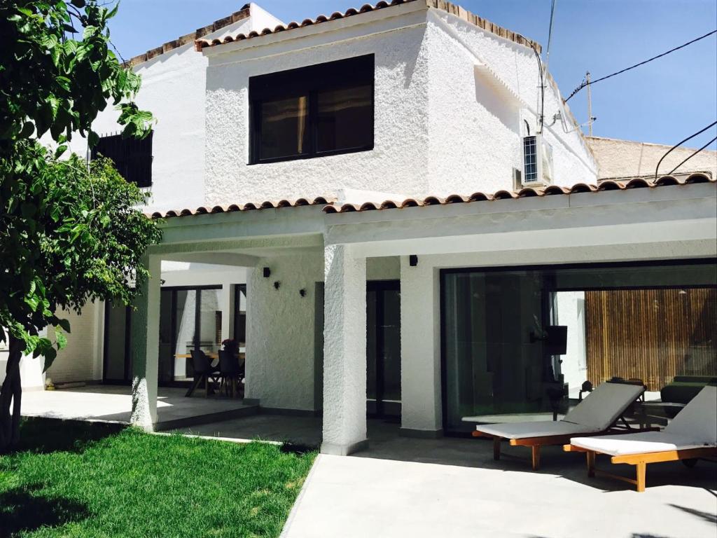 uma casa branca com um pátio e relvado em Minimalist house by the Mediterranean sea. em Alicante