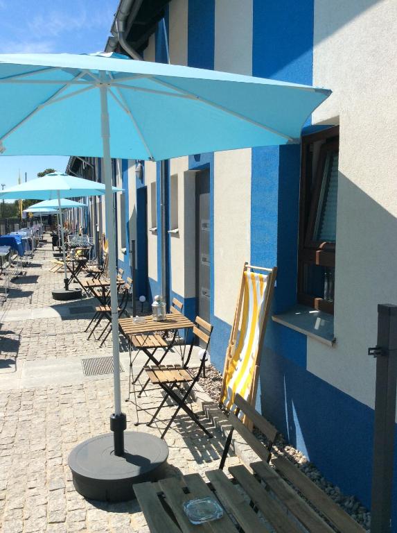 a table and chairs with an umbrella next to a building at Casa del Mar free Parking Only Adults for Young U45yrs in Międzyzdroje