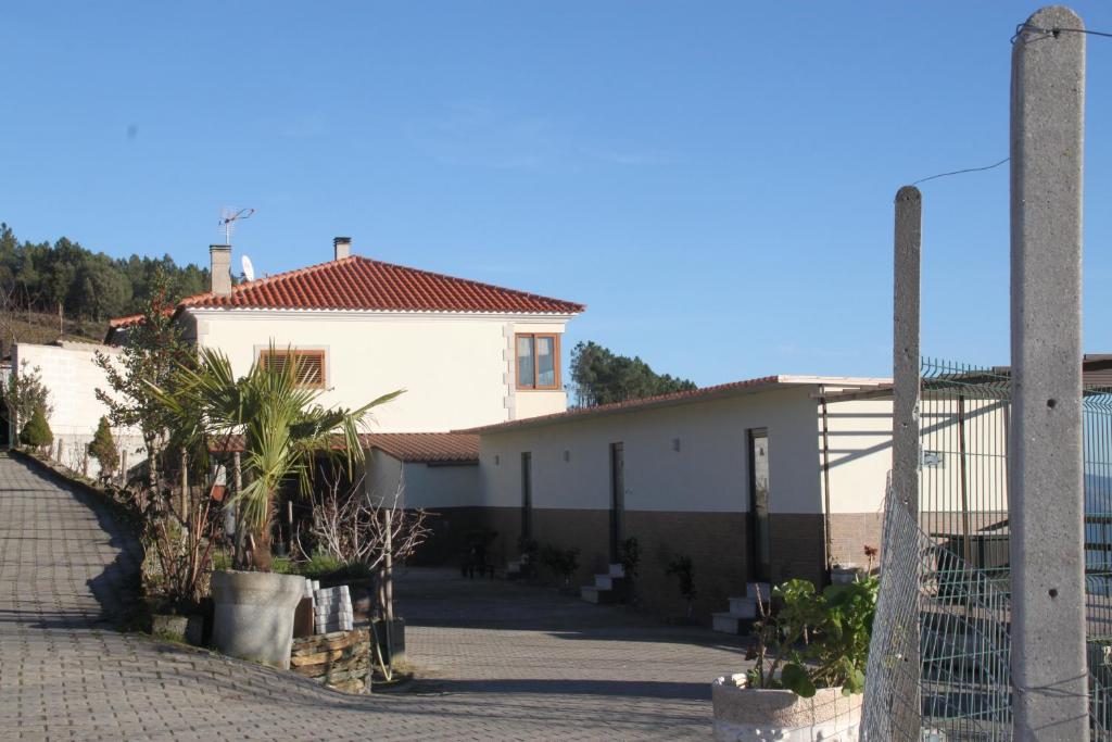 een wit gebouw met een hek ervoor bij Quinta Pedreira dos Anjos in Provesende