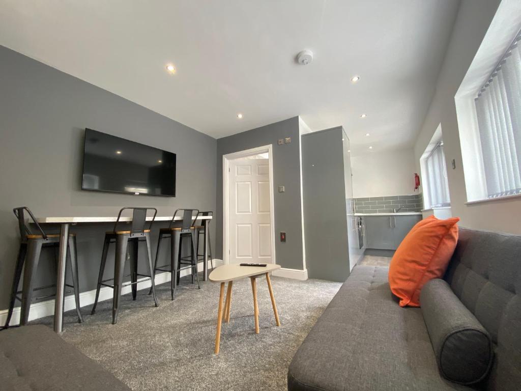 a living room with a couch and a table at Kensington Suite Sasco Apartments in Blackpool