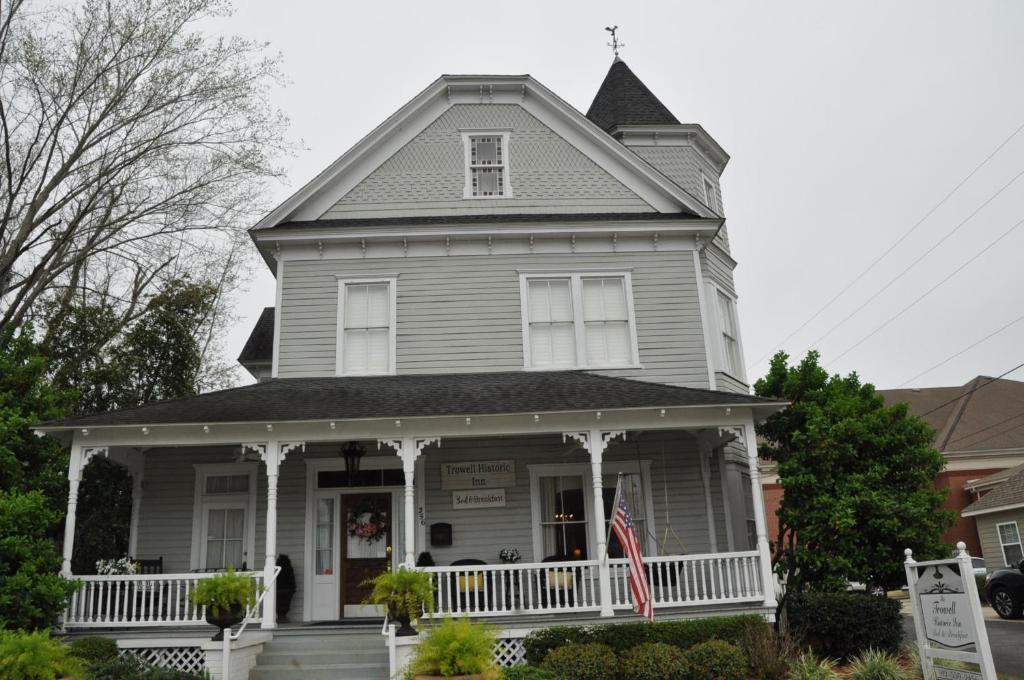 a gray house with a white porch at Trowell Historic Inn in Jesup