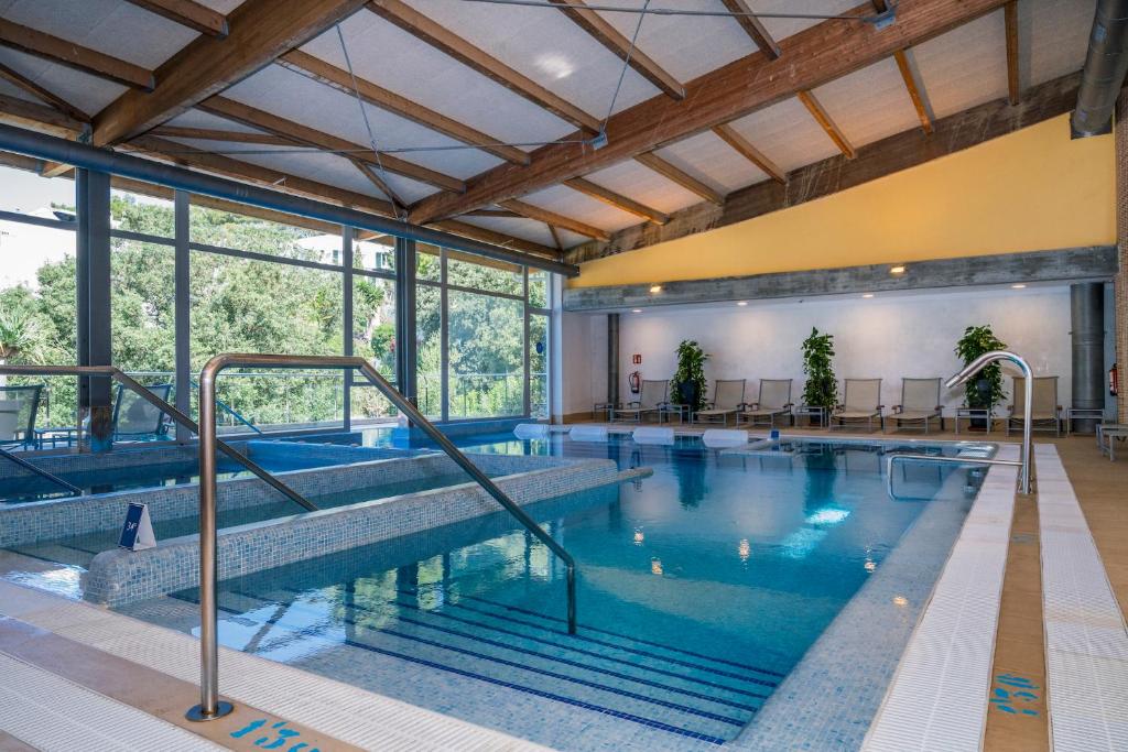 a large indoor swimming pool with blue water at ARTIEM Audax - Adults Only in Cala Galdana
