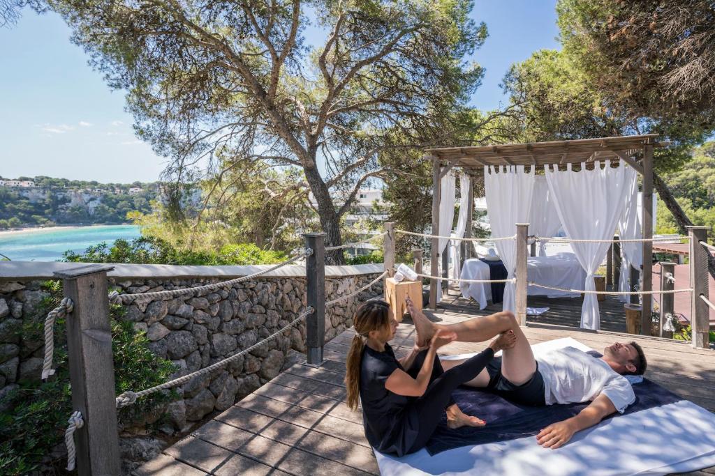 a man and a woman laying on a bed at ARTIEM Audax - Adults Only in Cala Galdana