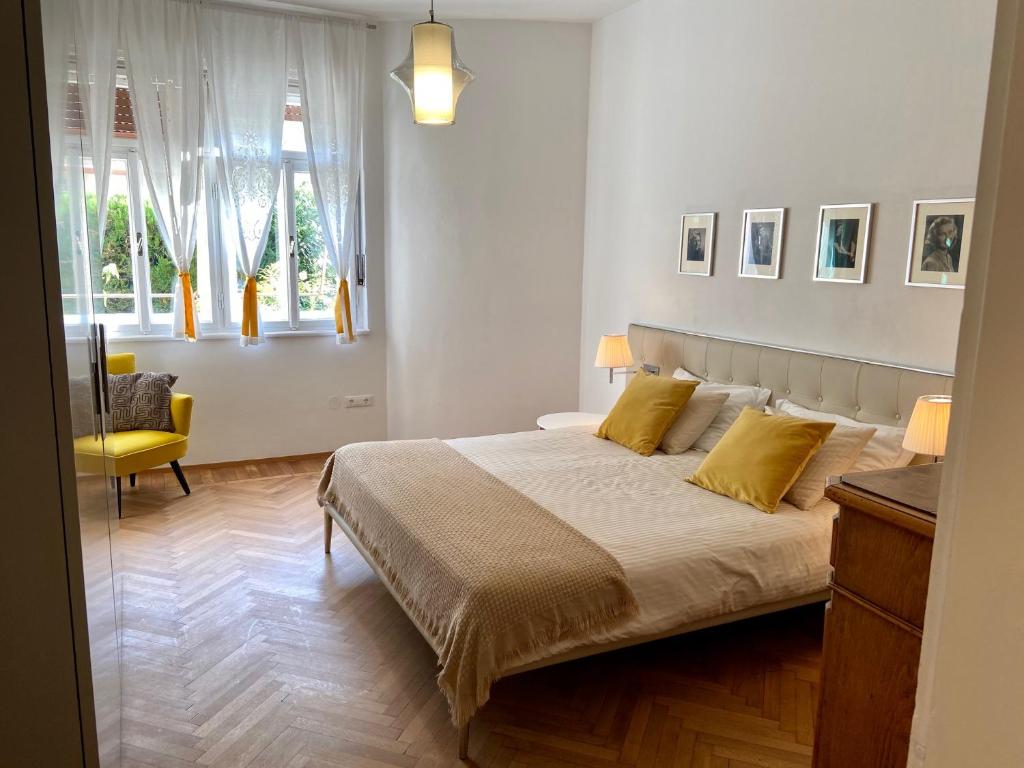 Delightful Villa Rina في ميرانو: غرفة نوم بسرير كبير مع مخدات صفراء
