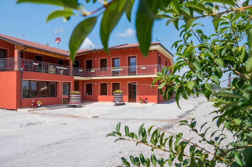- un bâtiment rouge avec un balcon en haut dans l'établissement Vino e Turismo, à San Defedente di Cervasca
