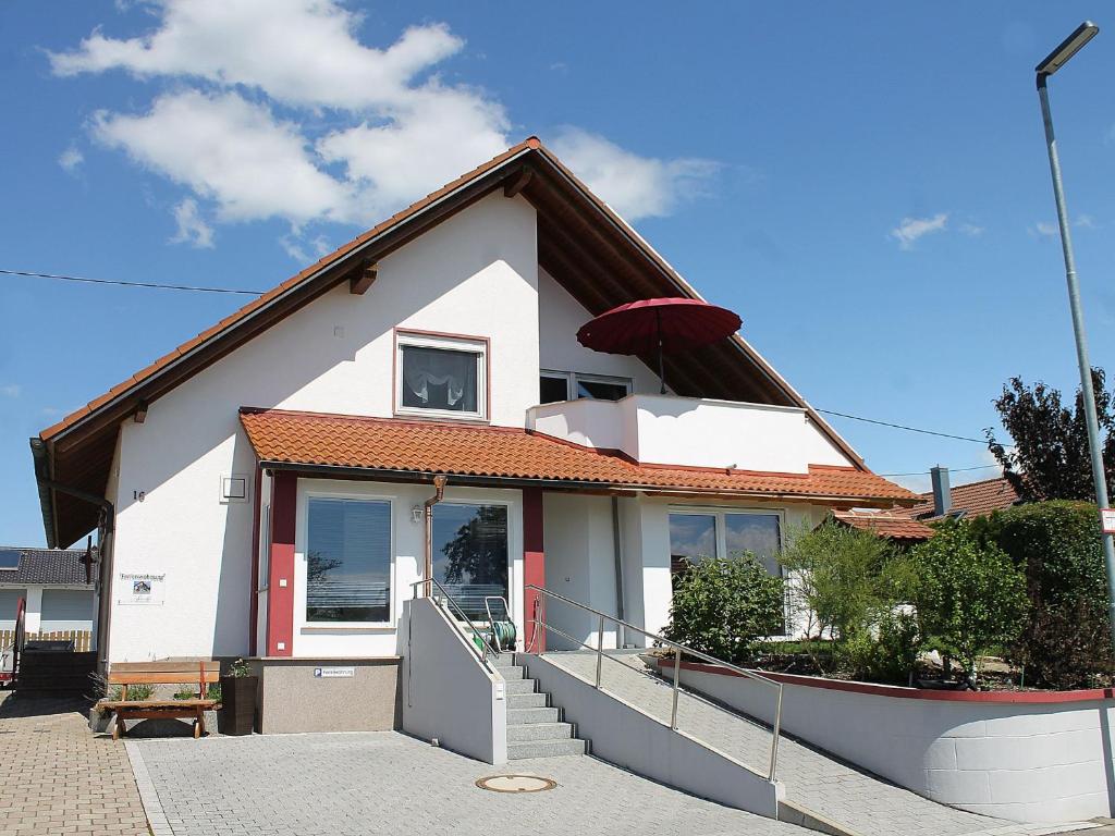 uma casa branca com um telhado vermelho em Ferienwohnung Arnold Laubbach em Ostrach