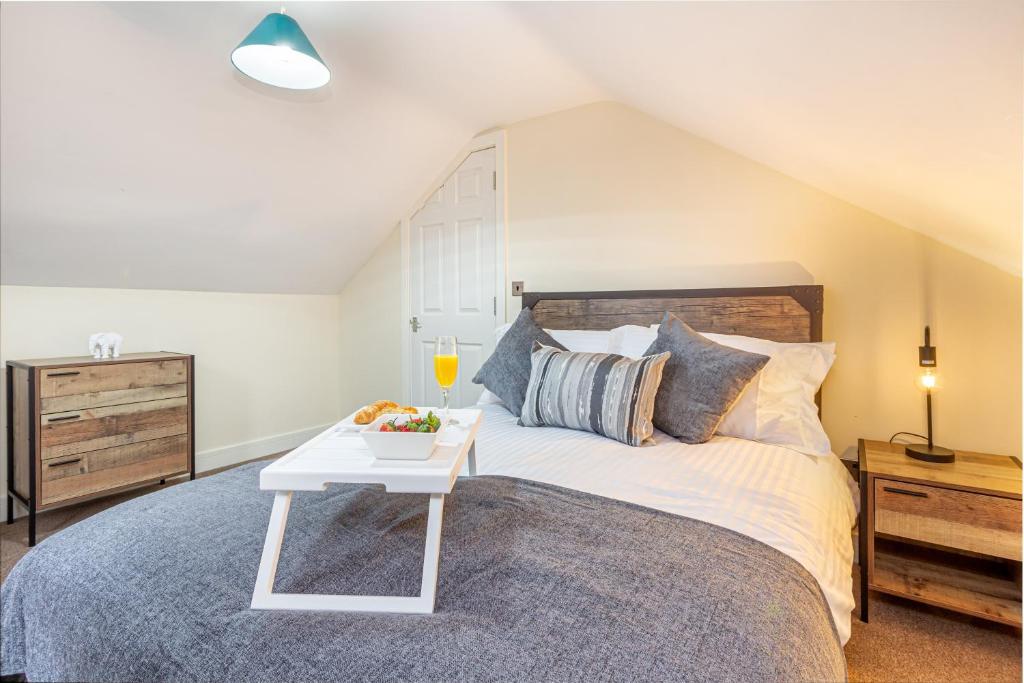 a bedroom with a large bed with a table on it at Guest Homes - Carriage Court in Worcester