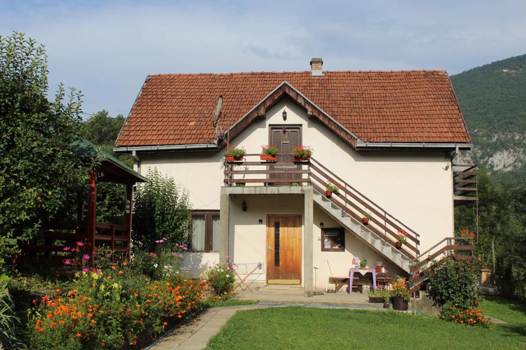 a white house with a balcony with flowers on it at Apartment Sijakovic in Mokra Gora