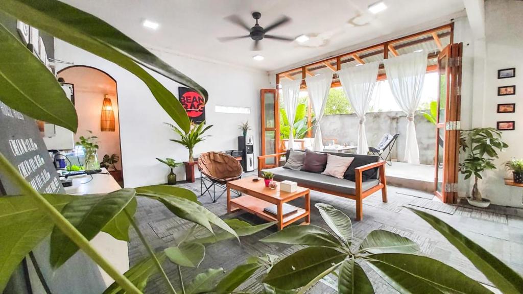 a living room with a couch and some plants at Beanbag Bintan Backpacker in Kangkakawal