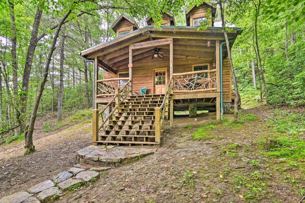 una cabaña de madera en el bosque con una escalera que conduce a ella en Quiet Balsam Grove Cabin Porch, Hot Tub, Dogs OK, en Balsam Grove