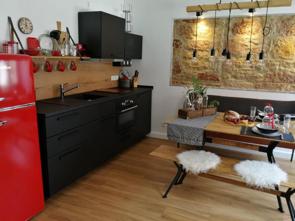 uma cozinha com um frigorífico vermelho e uma mesa em Ferienwohnung Gugel em Kandern