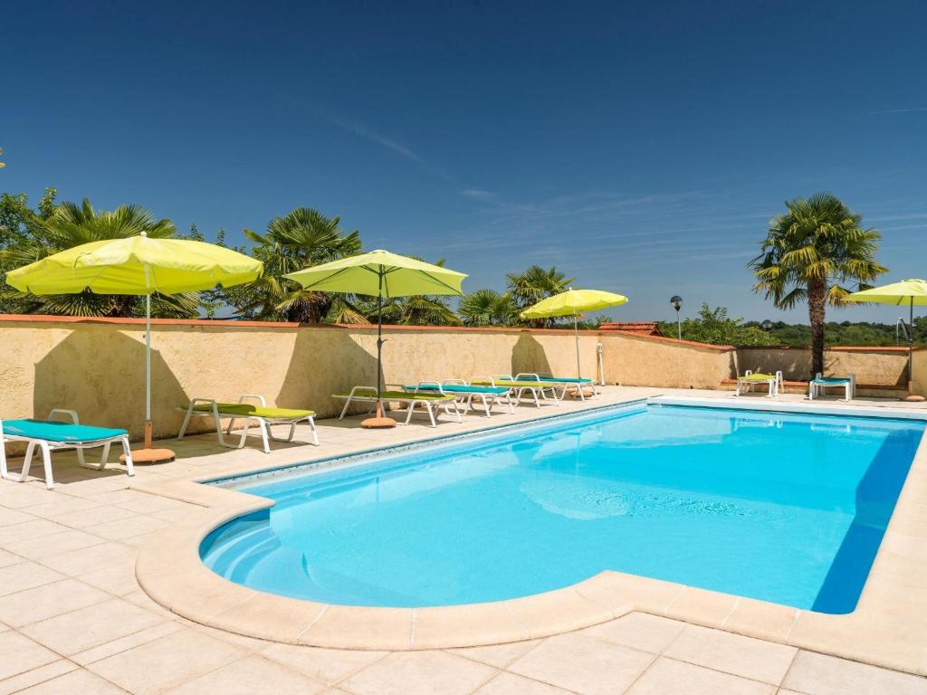 a swimming pool with chairs and umbrellas at Logis Hôtel L'Adourable Auberge in Soublecause