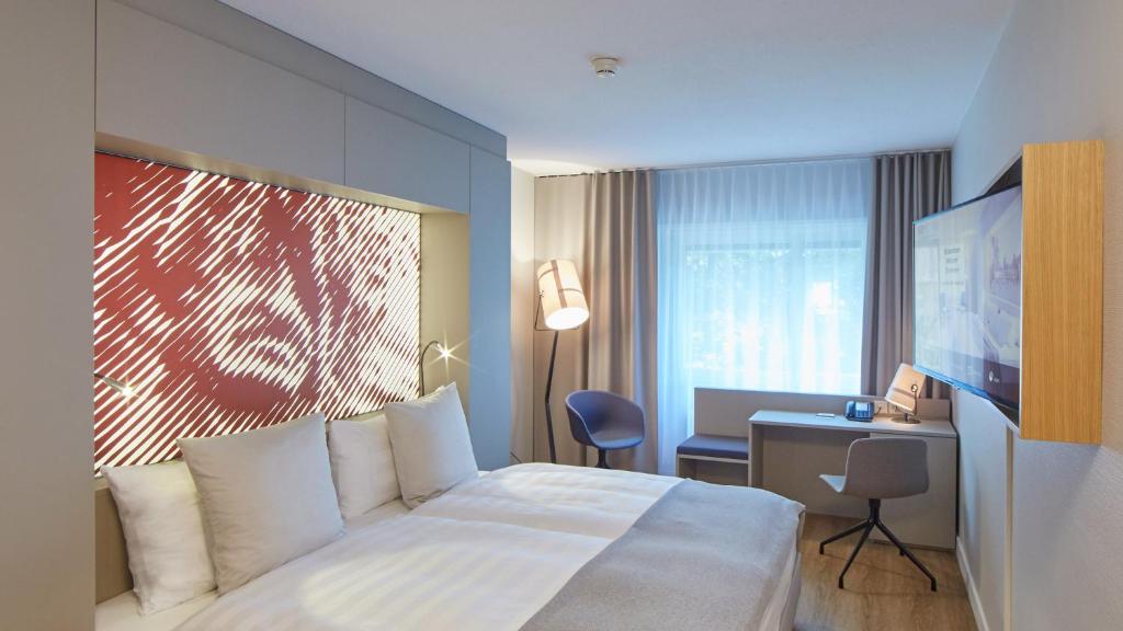 a hotel room with a white bed and a desk at Hotel Wettstein in Basel