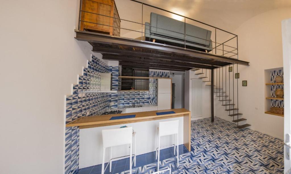 um quarto com uma escada e um balcão com cadeiras em Blu Marina em Vietri
