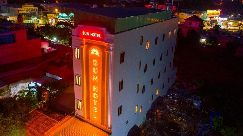 a building with a neon sign on it at night at SUN HOTEL in Thu Dau Mot