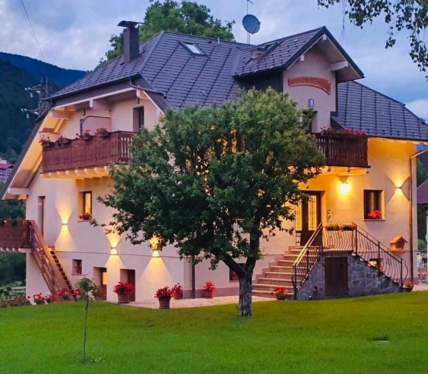 una grande casa bianca con un albero in cortile di Hotel Rosengarten a Tarvisio