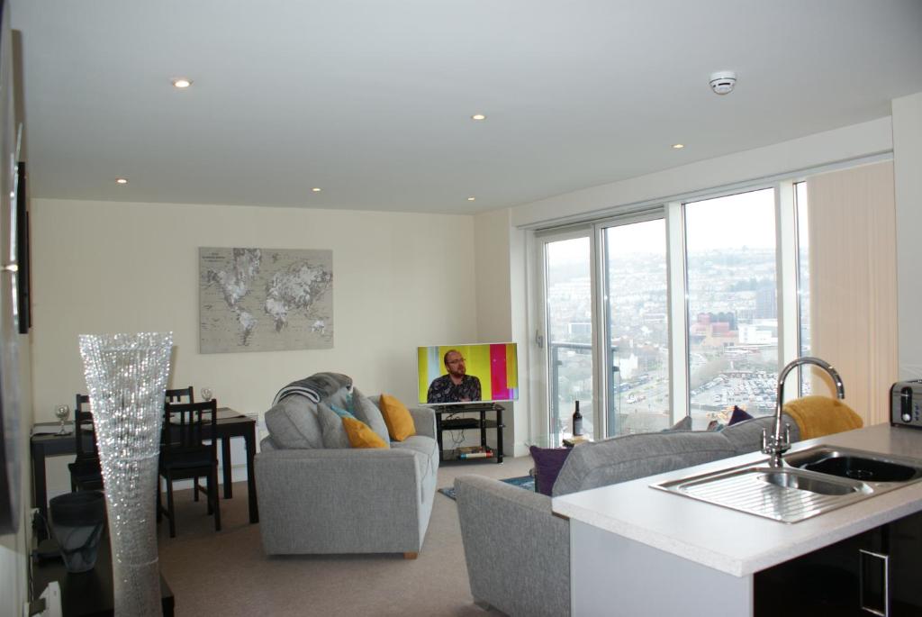sala de estar con sofá y mesa en Coastal City Rooms - Waterfront, en Swansea