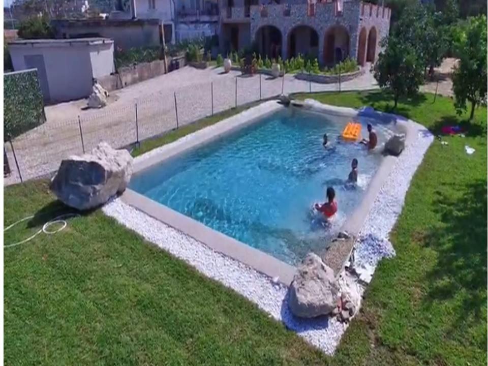 - une piscine dans une cour avec des personnes dans l'établissement residenza monarka, à Marina di Davoli