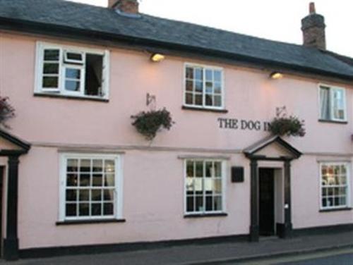 een wit gebouw met een hondenhok erop geschreven bij The Dog Inn in Halstead