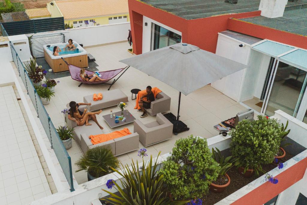 an overhead view of a patio with people sitting in chairs and an umbrella at Bica, luxury heated penthouses with jacuzzi and large terrace in Baleal in Baleal