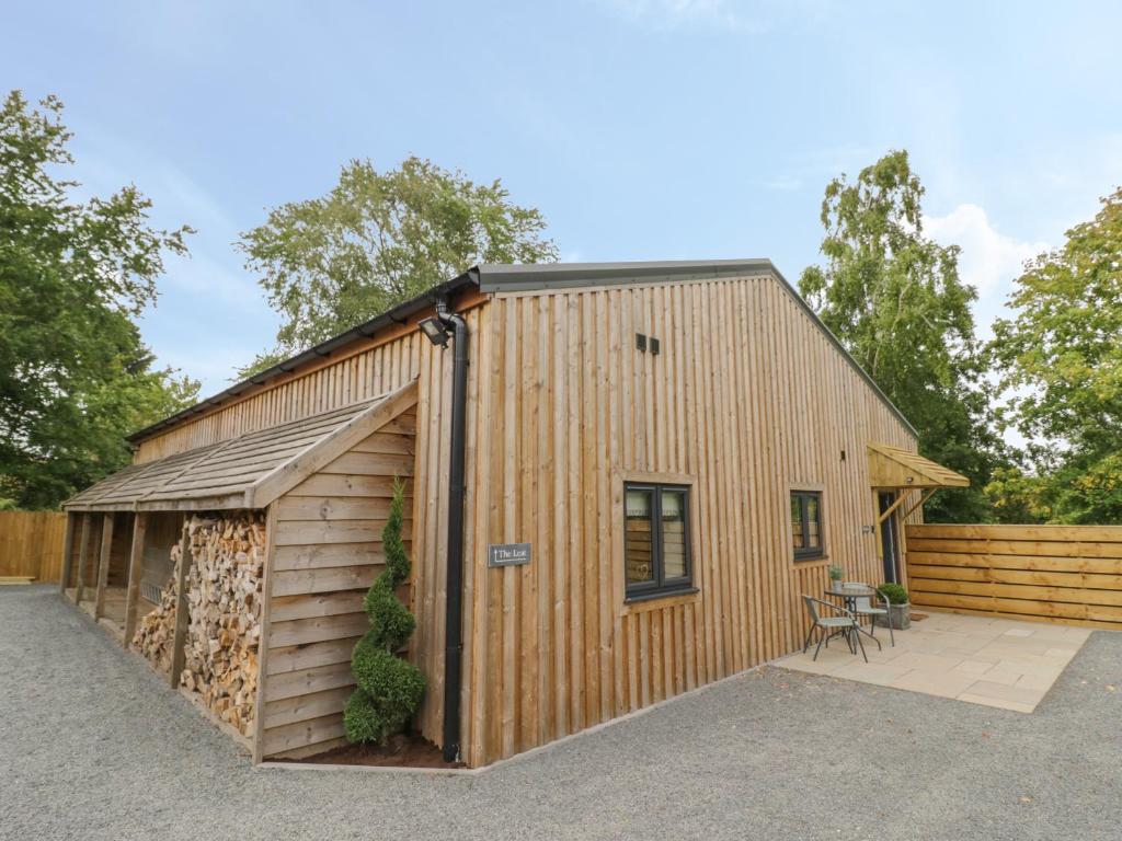 un gran edificio de madera con garaje en The Barn, en Redditch