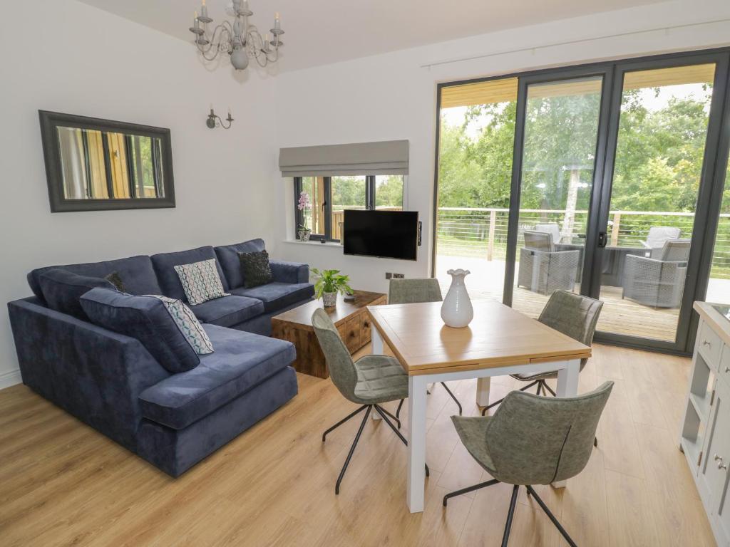 a living room with a blue couch and a table at The Barn in Redditch