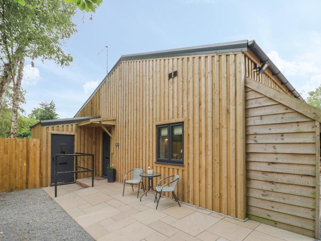 a wooden house with a patio and a table at The Leat in Redditch