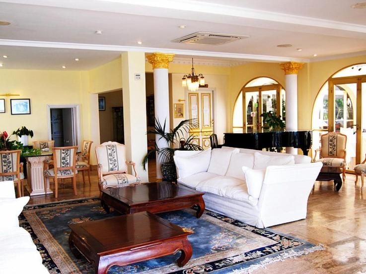 een woonkamer met een witte bank en een tafel bij Hotel El Dorado in Carboneras