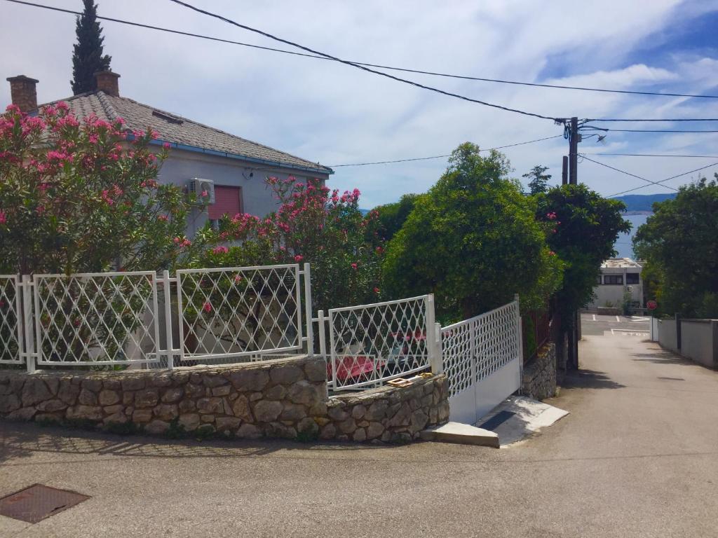 ein weißer Zaun vor einem Haus in der Unterkunft Holiday House Crik in Crikvenica