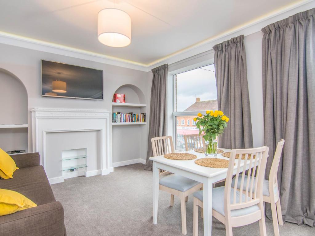 a living room with a white table and chairs at Fab Apartment in Loughborough