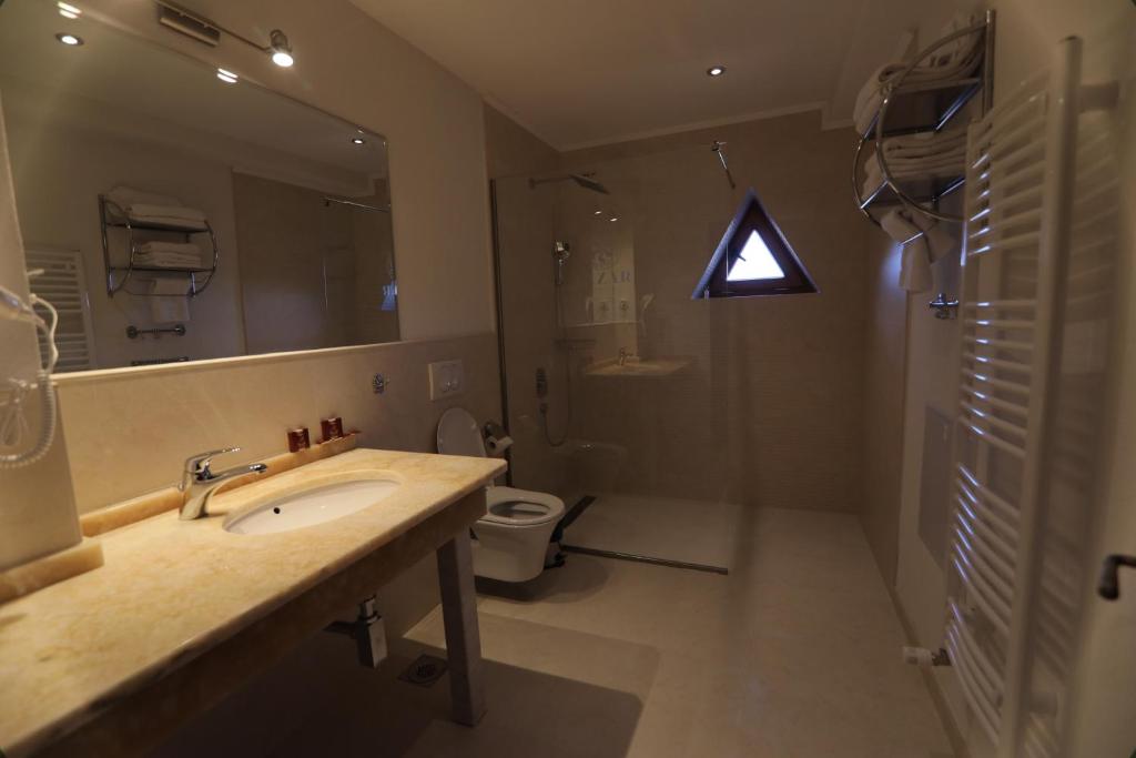 a bathroom with a sink and a shower and a toilet at Lazar Winery Tourism B&B in Rosoman