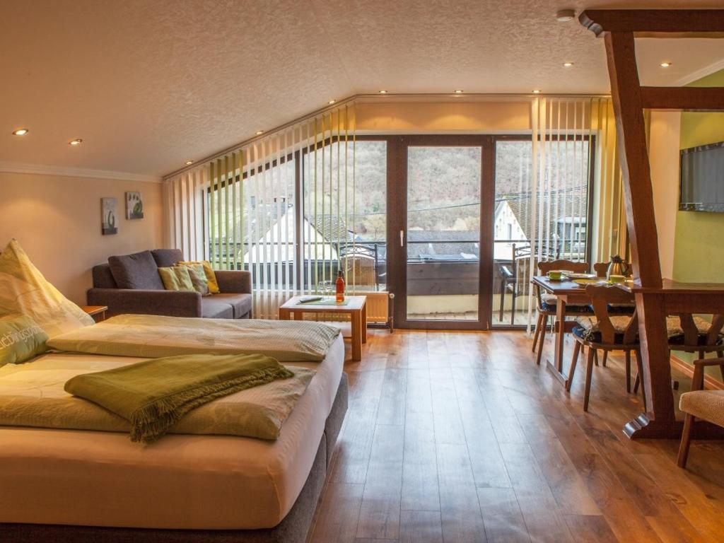ヴァルヴィヒにあるFerienweingut Steinのベッド2台とリビングルームが備わる広い客室です。