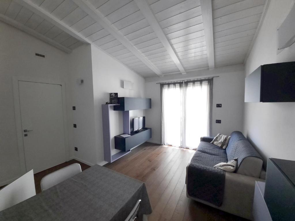ein Wohnzimmer mit einem Sofa und einem Tisch in der Unterkunft Dro Suite in Dro