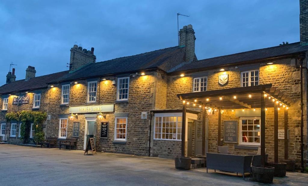 a large brick building with lights on it at The Farmers Arms Inns in Catterick Bridge