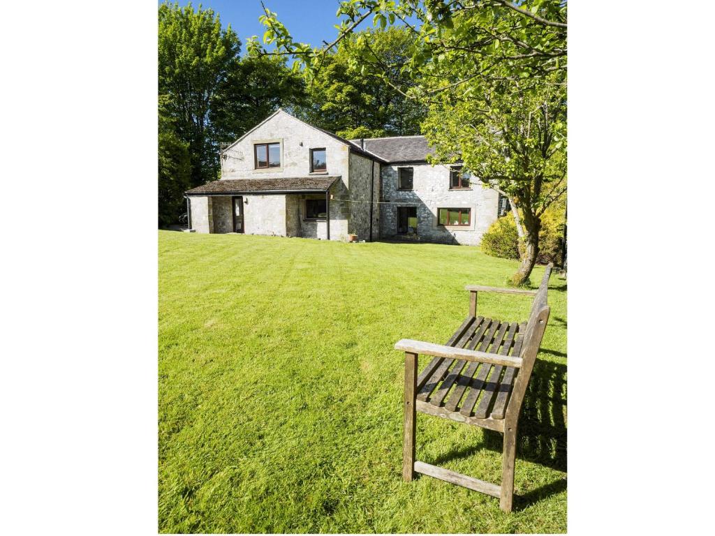 a wooden bench sitting in front of a house at Foxlow Coach House in Buxton