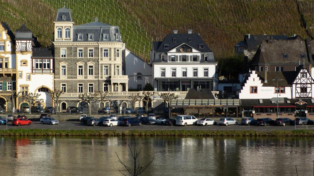 a city with cars parked in a parking lot next to a river at Ferienwohnungen am Stadtpalais in Bernkastel-Kues