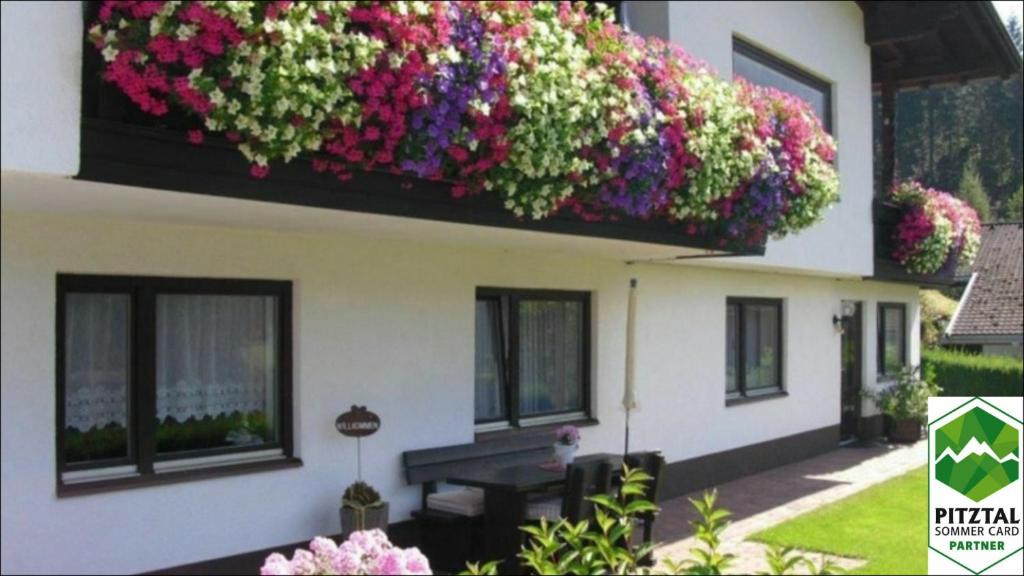 a building with flowers on the side of it at Ferienwohnung Reinstadler in Jerzens