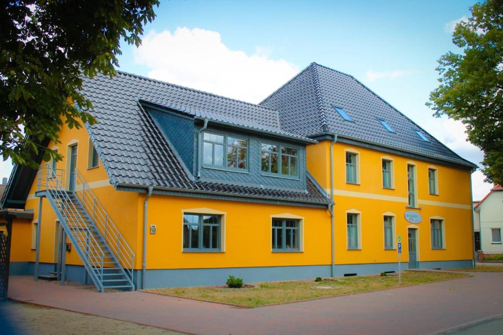 uma casa amarela com um telhado preto em Gästehaus Burgblick em Neustadt-Glewe