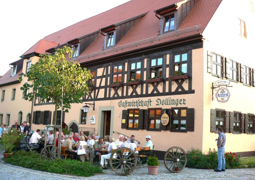 un gruppo di persone seduti fuori da un edificio di Gasthaus Dollinger a Dinkelsbühl