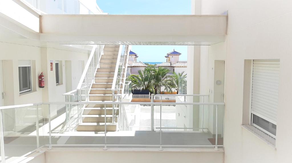 a glass staircase in a house with a view of a courtyard at La Belle bleue in La Marina