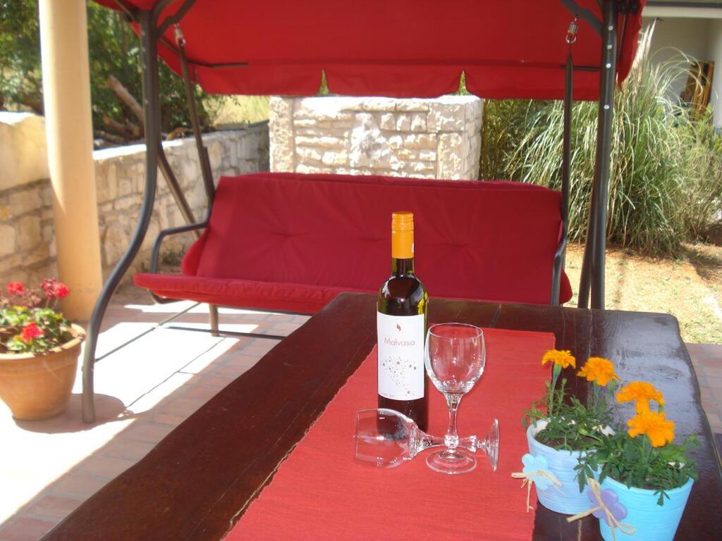 a bottle of wine sitting on a table with glasses at Apartment Premantura in Premantura