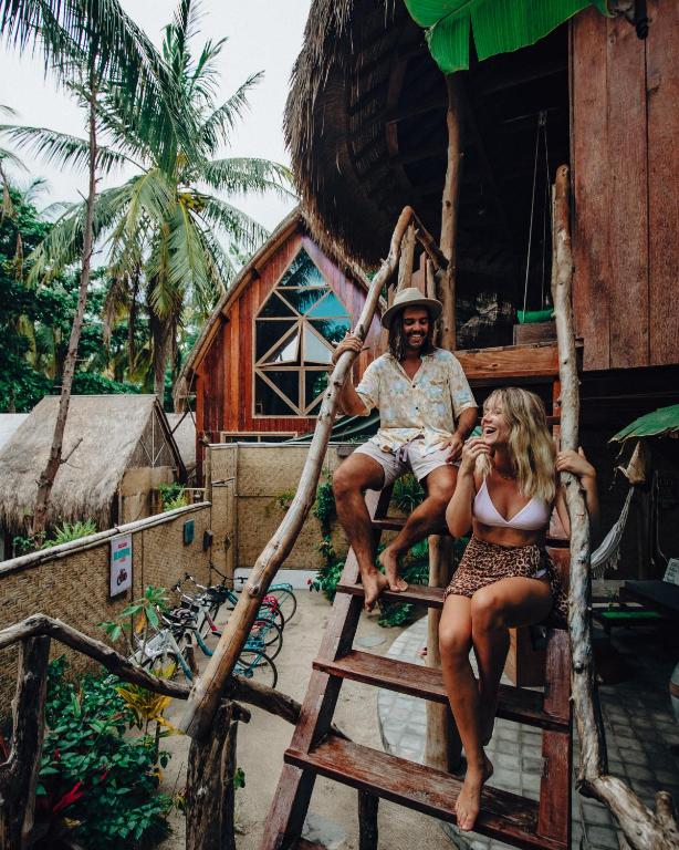 a man and a woman sitting on a swing at Gili Treehouses Private Pool Hideaway in Gili Trawangan
