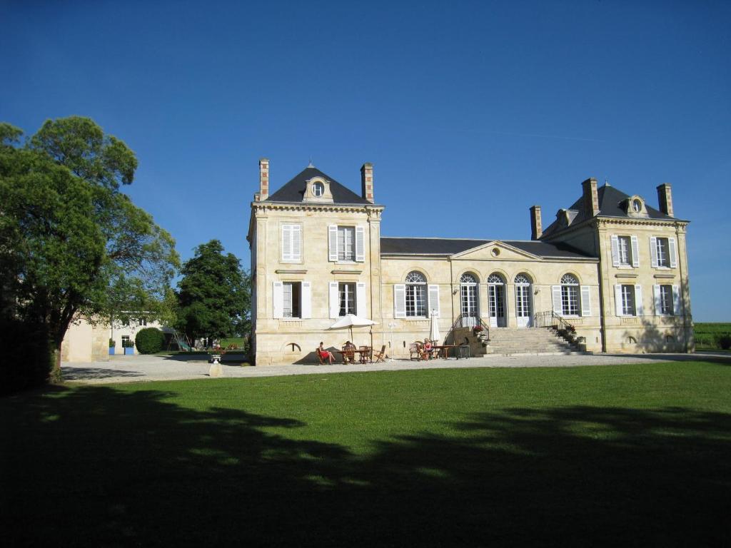una casa grande con un gran campo de hierba delante de ella en La France - Gite Chateau en Beychac-et-Caillau